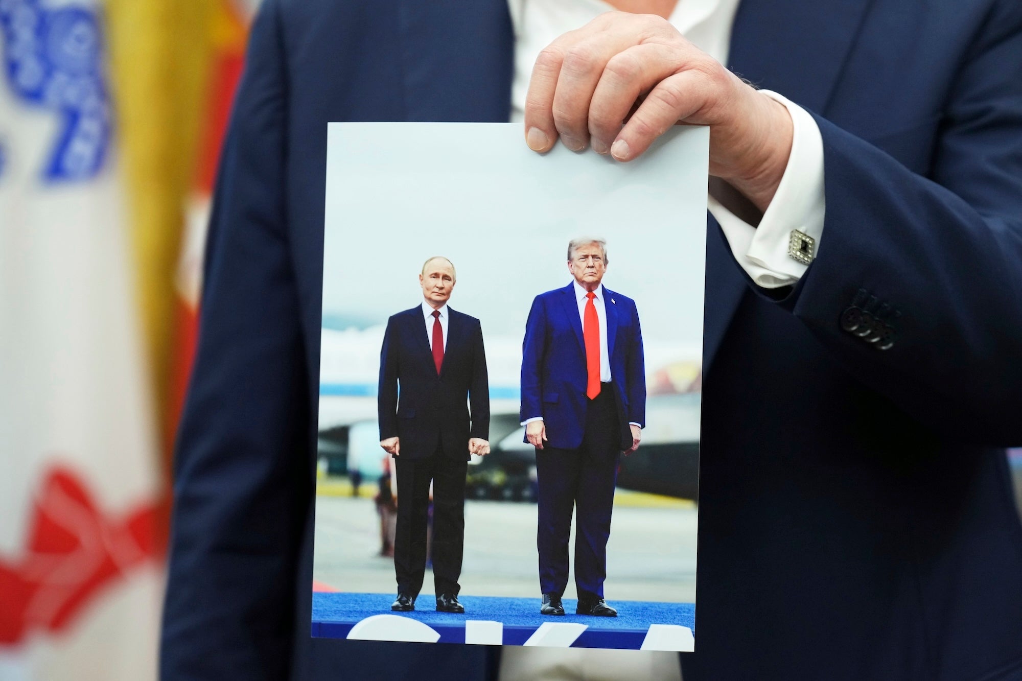 President Donald Trump holds a photo of himself with Russian President Vladimir Putin during an announcement in the Oval Office of the White House, Friday, Aug. 22, 2025, in Washington. 