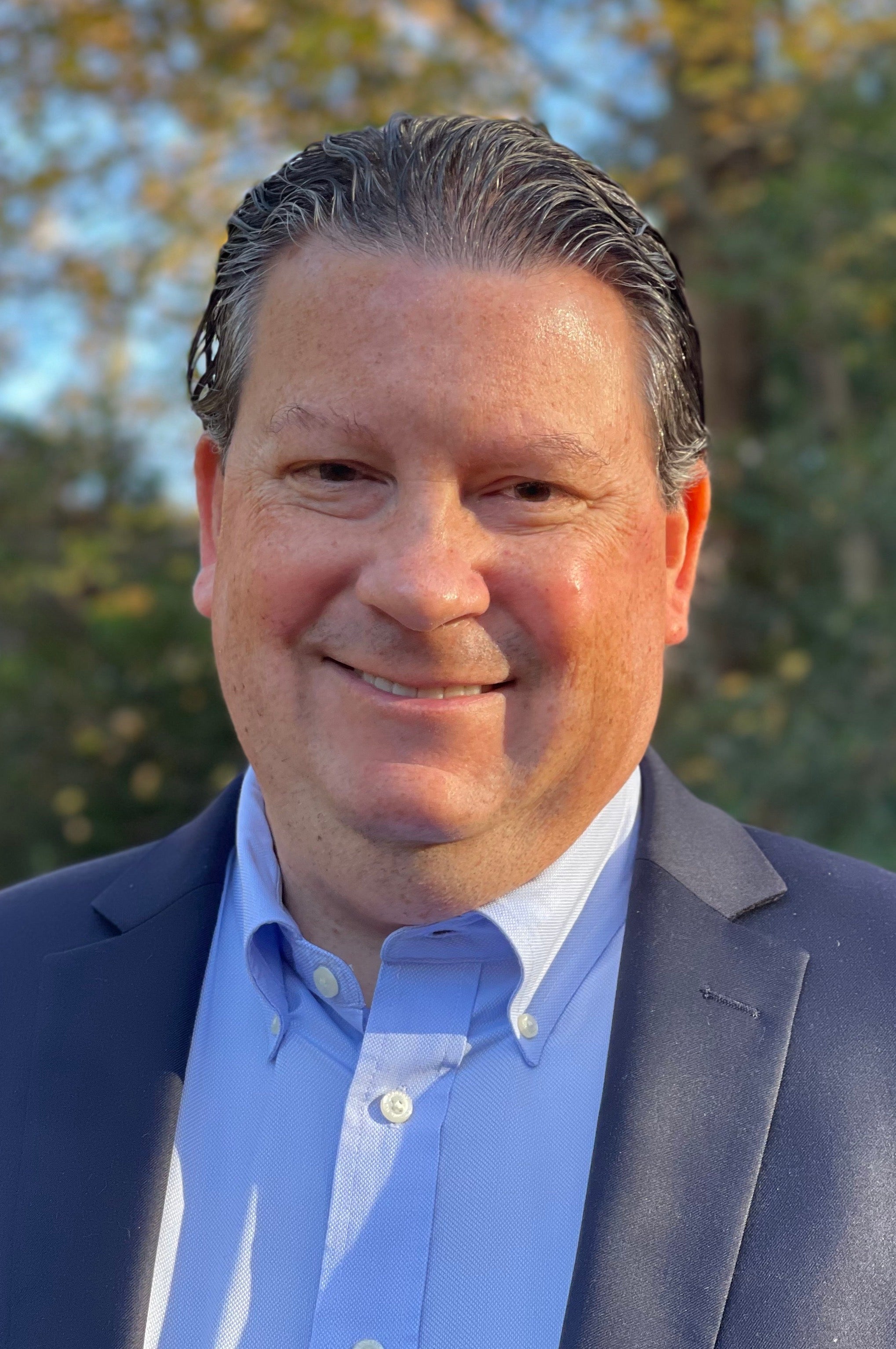 Eric Miller Headshot; Man in light blue shirt and black jacket