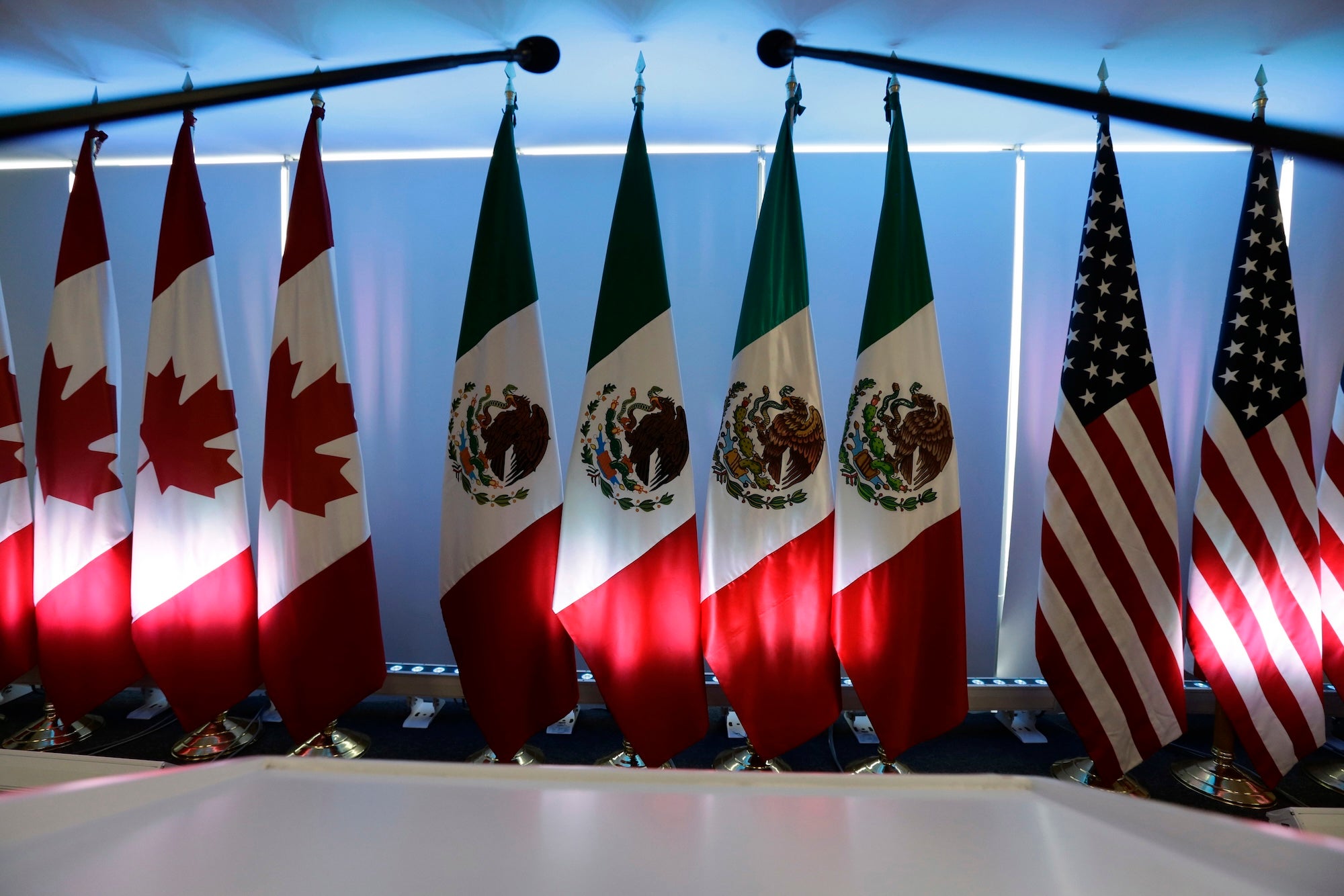 National flags representing Canada, Mexico, and the U.S. are lit by stage lights at the North American Free Trade Agreement, NAFTA, renegotiations, in Mexico City, Tuesday, Sept. 5, 2017.