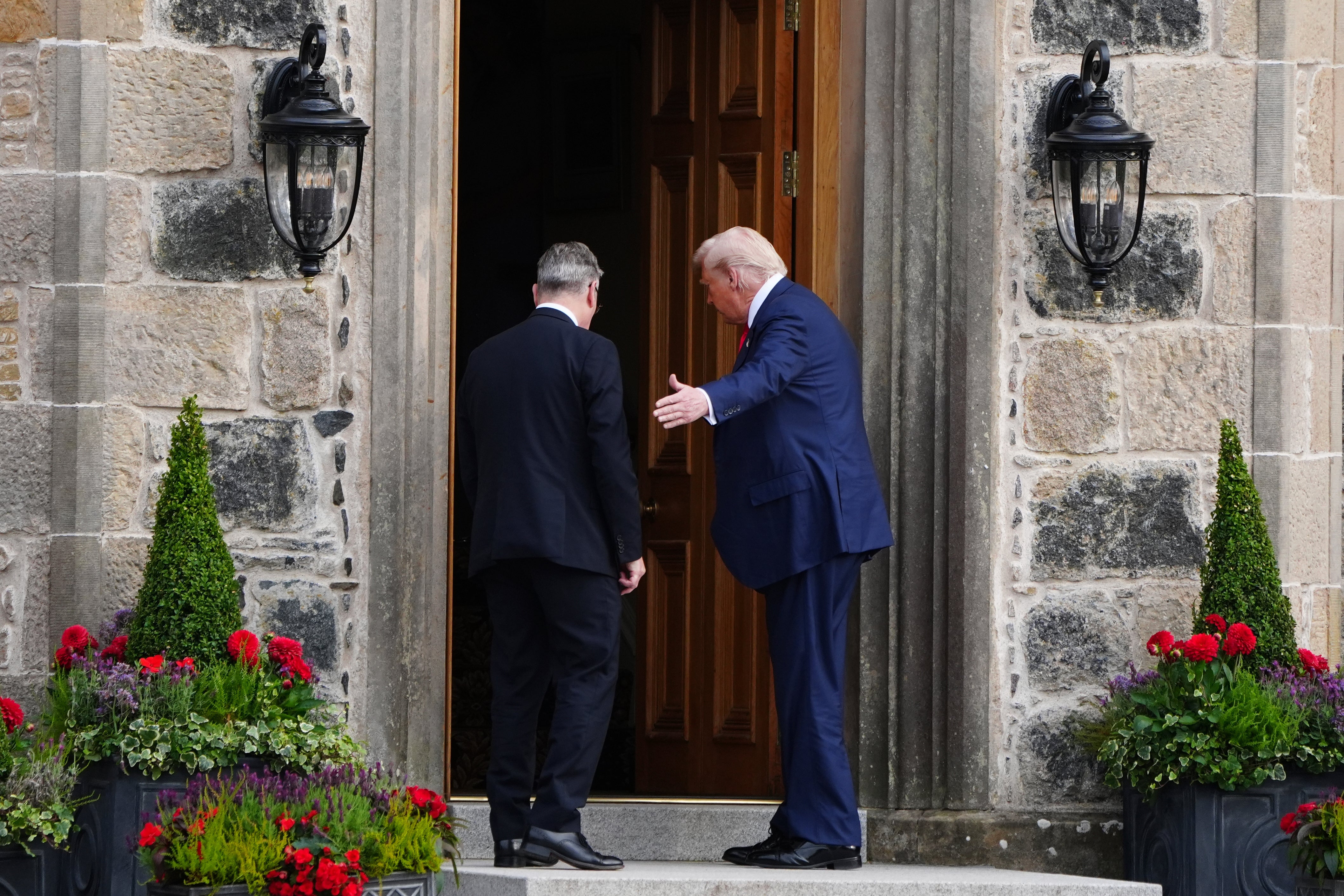 U.S. President Donald Trump, right, and British Prime Minister Keir Starmer walk at Trump International Golf Links in Aberdeenshire, Scotland, Monday, July 28, 2025. 