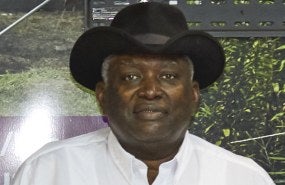 Andrew Williams is pictured from the shoulders up wearing a white button-up shirt and a black hat.