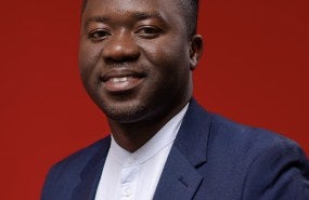 Headshot of Jones Kanjira with a red background.
