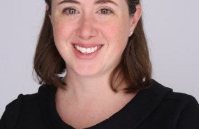Headshot of Caitlin Grady with a gray background.