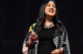 Angel Hsu speaking in front of a black background