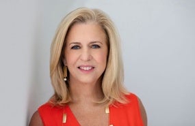 Blonde woman with orange top smiling