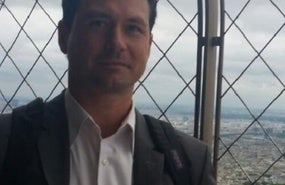 Jake Braun headshot showing man with brown hair in button down shirt and jacket
