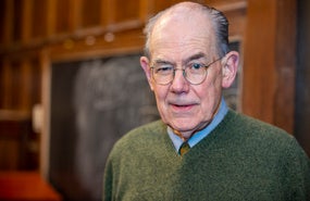 John Mearsheimer headshot; photograph of older man with glasses wearing a green sweater