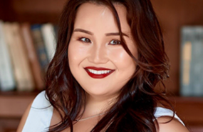 Headshot of Ajar Chekirova in white shirt, smiling