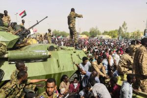 Sudanese soldiers stand guard around armored military vehicles as demonstrators continue their protest against the regime near the army headquarters in Khartoum.