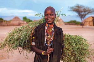 A young woman from the Erbore tribe in Ethiopia carries grasses.