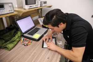 DACA recipient and engineering student works on a circuit board.