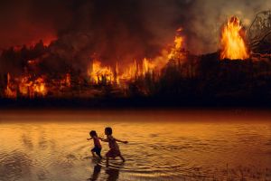 Children play in lake next to raging fire in the Amazon Rainforest.