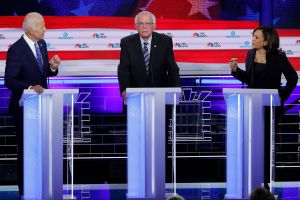 Former Vice President Joe Biden and Senator Kamala Harris debate as Senator Bernie Sanders listens