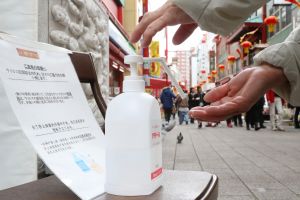 A passer-by disinfects their hands at a festival in Kobe, Hyogo Prefecture, Japan.
