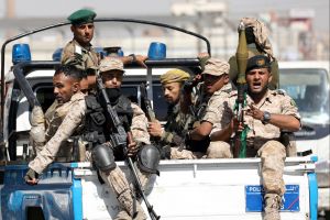 Houthi troops ride on the back of a police patrol truck after participating in a Houthi gathering in Sanaa, Yemen