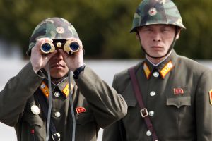 North Korean soldiers look to the South through binoculars while on patrol.