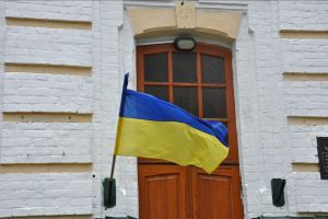 Flag of Ukraine waving in front of a wooden door.