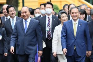 People in suits walking down a sidewalk, some wearing surgical face masks