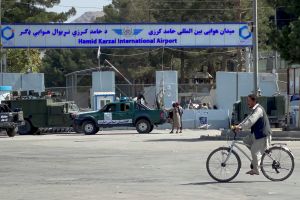 Man on bicycle in front of Hamid Kerzal International airport in Kabul