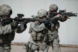 Three soldiers in camouflage holding weapons