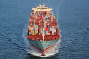 Containers are stacked on the deck of the cargo ship on the ocean.