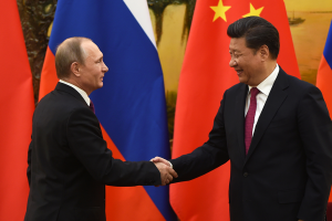 Against a backdrop of Russian and Chinese flags, Russian President Vladimir Putin shakes hands with Chinese President Xi Jinping at the end of a joint press briefing in Beijing's Great Hall of the People.