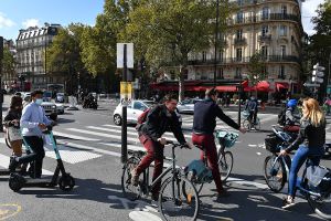 A group of people on bikes wait at a crosswalk