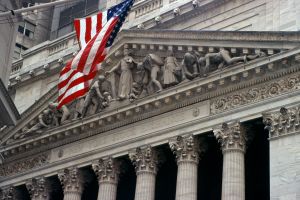 Facade of the New York Stock Exchange, with an American flag in the foreground