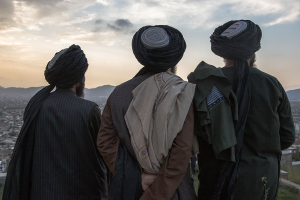 Three men overlooking a city and sunrise.