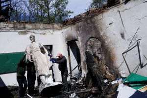 Ukrainians remove the statue of Hryhoriy Skovoroda after a Russian bombing hit the museum.