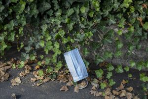 a blue face mask left on the ground