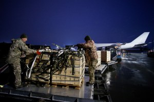 Ukrainian service members unload a shipment of US military aid