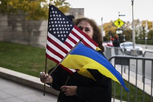 A woman holds US and Ukrainian flags