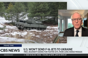 Screenshot of Ivo Daalder on CBS News at right, footage of tank at left