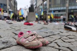 Children's shoes and people with Ukrainian flags