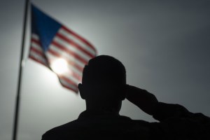 a soldier salutes the American flag