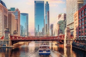A boat floats down the Chicago River on a clear day