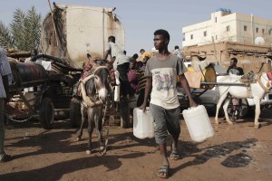 People gather to collect water in Khartoum, Sudan, Sunday, May 28, 2023.