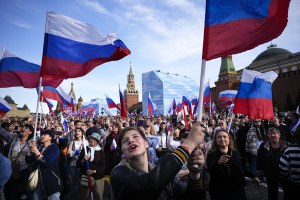 Thousands of people wave Russian national flags as they gather on Red Square 