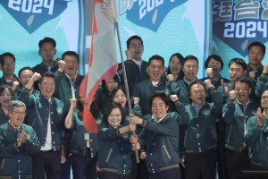 Taiwanese President Tsai Ing-wen, center left, hands over a flag to the party's presidential candidate William Lai during the party congress of the ruling Democratic Progressive Party