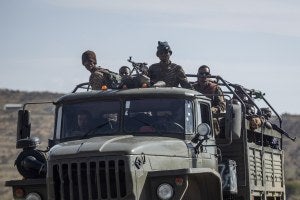 Ethiopian government soldiers ride in the back of a truck on a road in the Tigray region