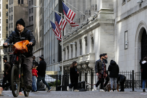 People pass in front of the New York Stock Exchange on March 21, 2023.