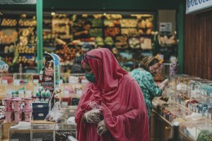 A woman stands in a grocery store examining food options.