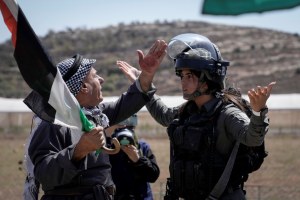 A Palestinian protester argues with Israeli security forces to prevent shooting tear gas at Palestinian protesters during a demonstration against Israeli settlements in the village of Qaryout, near the West Bank city of Nablus, Friday, Sept. 15, 2023. 