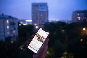 A user holds a smartphone with an opened Facebook page in Moscow, Russia