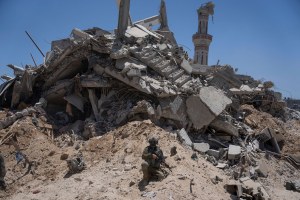 Israeli soldiers walk in the southern Gaza Strip