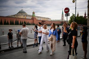 People walk along closed empty Red Square with the Kremlin Wall