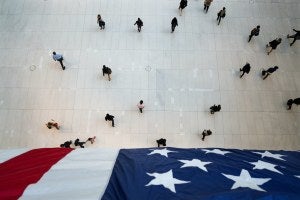 People walk under an American flag