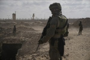 Israeli soldiers take up positions next to an entrance of a tunnel in Gaza