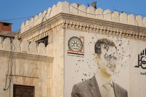 An image of Syrian President Bashar Assad, riddled with bullets, on the facade of the provincial government office in Hama, Syria.